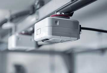 Close-up of modern garage door opener sensor installed in an Antelope CA home.