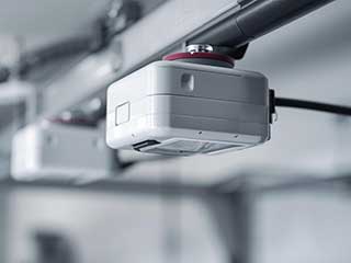 Close-up of modern garage door opener sensor installed in an Antelope CA home.