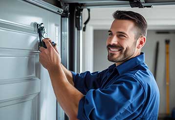 Garage door specialist in blue uniform performing service and repairs inside a residential Antelope garage.