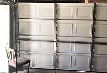 Interior shot showing newly installed steel sectional garage door with reinforced tracks